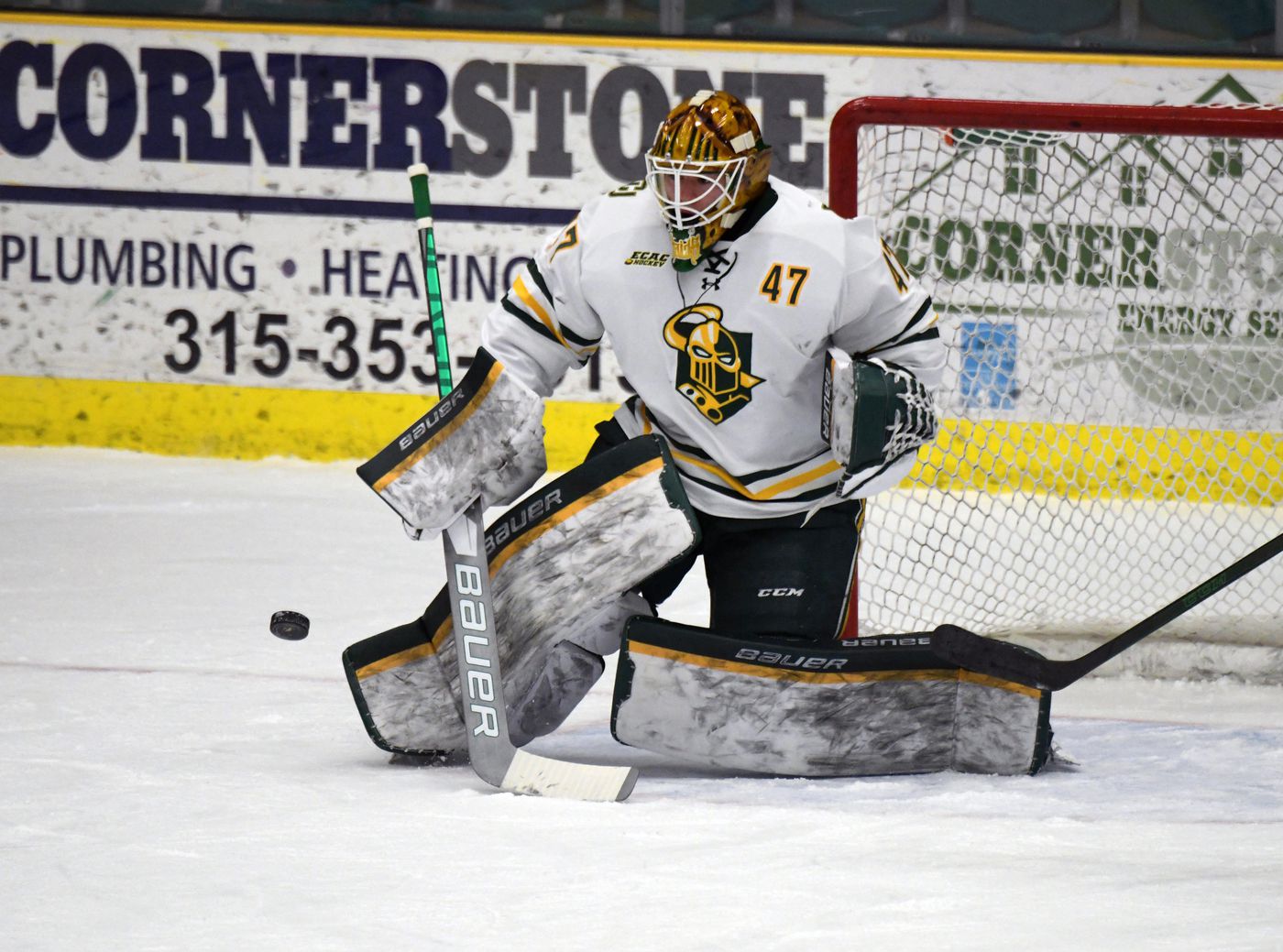 Clarkson University goalie makes a save in the butterfly position.